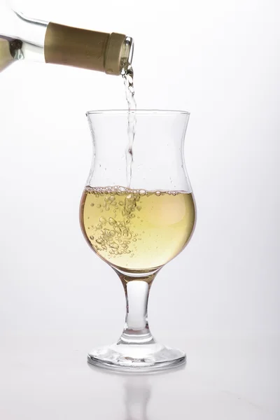 Vinho branco derramando em um copo — Fotografia de Stock