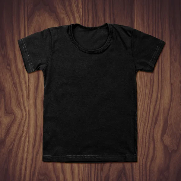 Zwart leeg t-shirt op houten achtergrond — Stockfoto