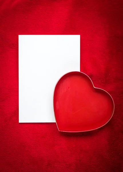 Сердце с пустой карточкой на красном фоне — стоковое фото