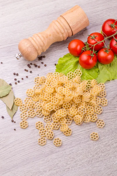 Pâtes, tomates et poivre sur fond de bois — Photo