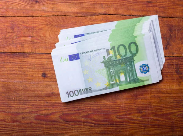 Primer plano de los billetes de 100 euros sobre fondo de madera — Foto de Stock