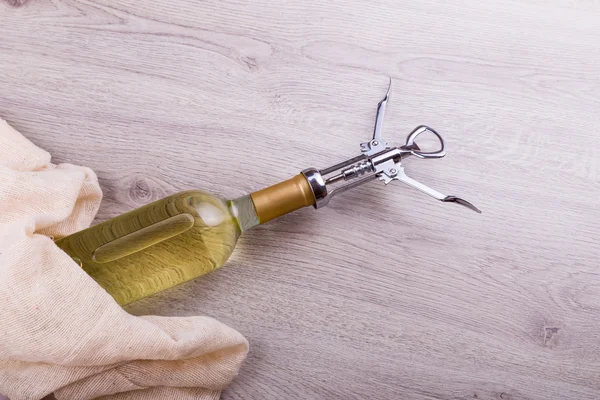 Fles wijn met corkscrew op houten achtergrond — Stockfoto