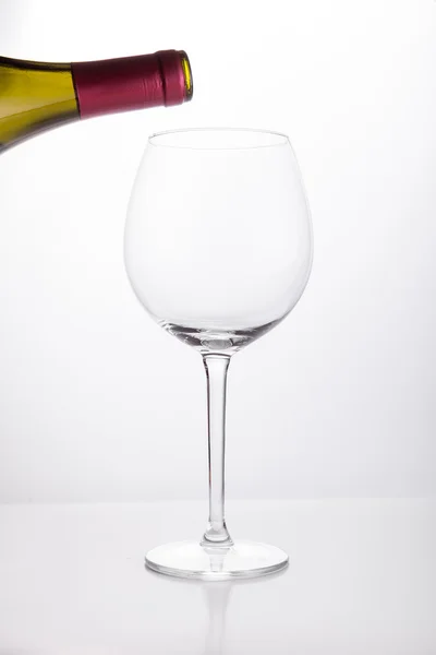 Vinho branco derramando em um copo de garrafa — Fotografia de Stock