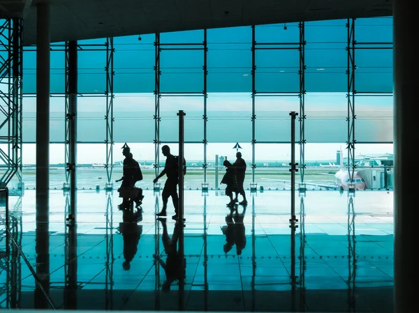 Personas con equipaje caminando en el aeropuerto — Foto de Stock