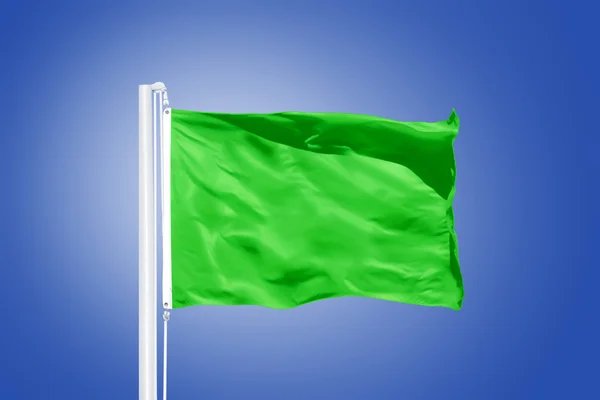 Green flag flying against clear blue sky — Stock Photo, Image