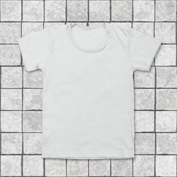Witte lege t-shirt op achtergrond tegel — Stockfoto