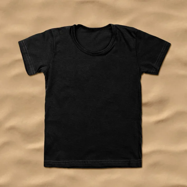 Zwart leeg t-shirt op zand achtergrond — Stockfoto