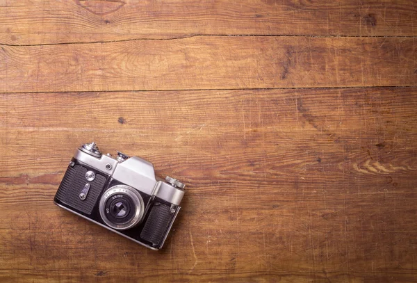 Retro camera op houten tafel achtergrond — Stockfoto