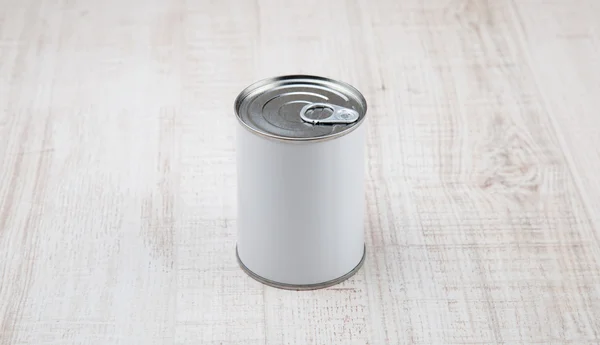 Lata de lata sobre fondo de madera blanca — Foto de Stock