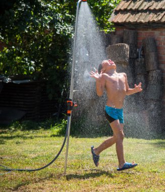 Çocuk bahçesinde sıcak gün duş altında