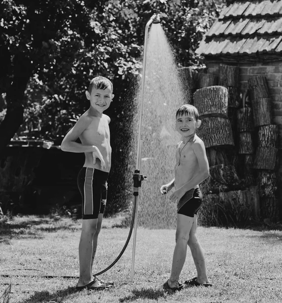 Boys under a shower in the garden — Stock Photo, Image