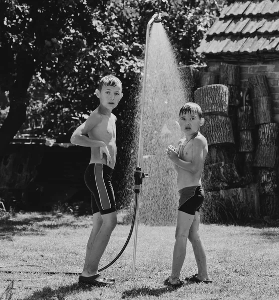 Boys under a shower in the garden — Stock Photo, Image