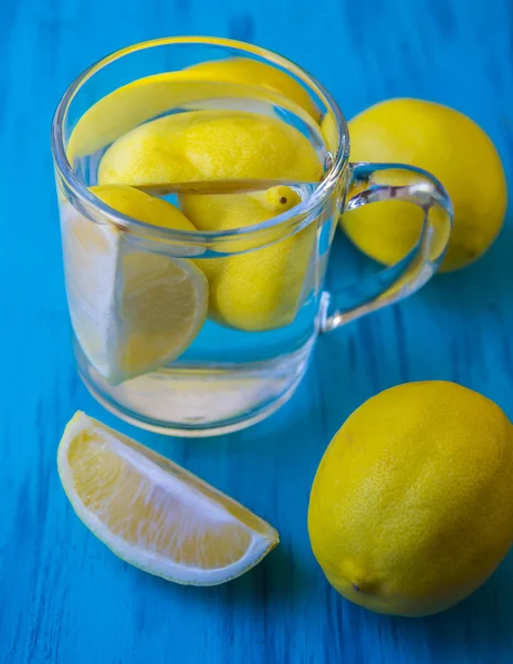 Água com um limão em um copo — Fotografia de Stock