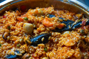 Paella hazırlığı. Paella geleneksel İspanyol yemekleri. Kızartma tavasında midye, karides, langoustine ve mürekkep balıklarıyla birlikte deniz ürünleri paella 'sı. Paella pişiriyorum, yakın plan. Akdeniz deniz ürünleri yemeği