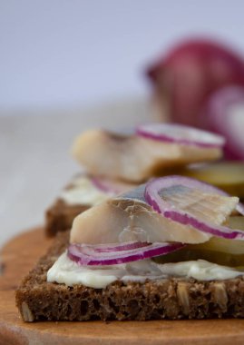 Ringa, soğan ve salatalıklı çavdar ekmeği sandviçi.