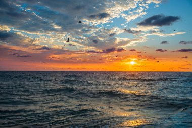 Açık denizde parlak turuncu gün doğumu. Deniz ufku. Denizin üzerinde güzel bir gökyüzü