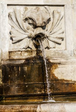 Taş bir fıskiyeden gelen su jeti. Şehirde sıcak bir yaz günü