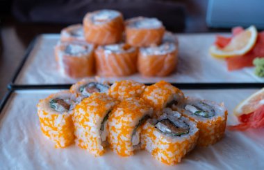 Somon, avokado ve peynirli suşi. Lezzetli yemekler. Balık ve pirinç..