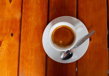 Tahta bir masada bir fincan kahve.