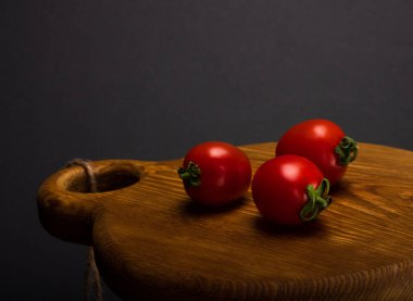 Tahta bir masanın üstünde taze kırmızı domatesler.