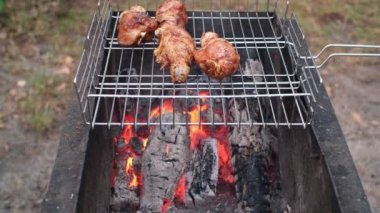 Kızarmış tavuk budu alevli ızgarada kızartılmış. Kömür ve duman. Dışarıda ızgara tavuk budu hazırlıyorum. Izgara yemek.