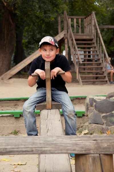 Der Junge auf der hölzernen Schaukel — Stockfoto