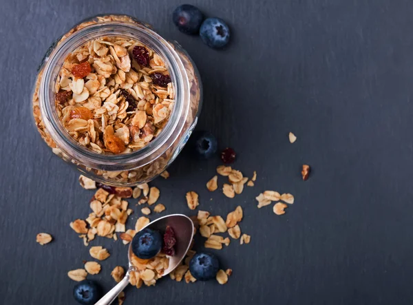 Granola in a glass jar on the black background — Stock Photo, Image
