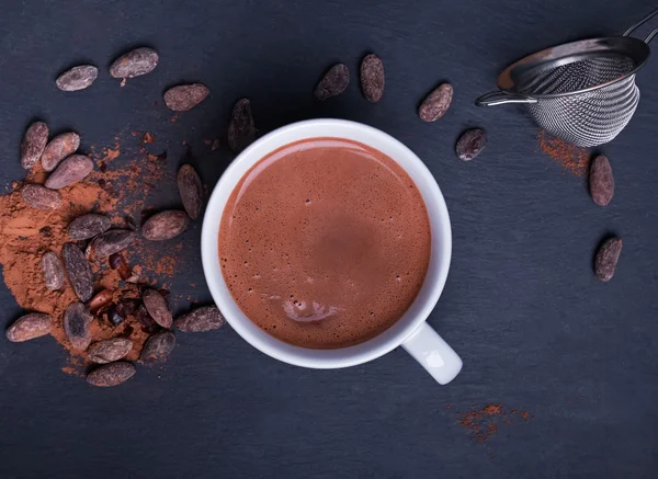 Cocoa in a cup and cocoa beans on the black background — Stock Photo, Image