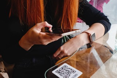 Lokanta veya kafede barkod qr 'yi tarayan kadın