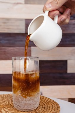 Mans el tonik ile cam içine espresso dökülen.