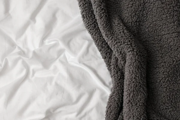 Белая кровать с мягкой серой простыней — стоковое фото
