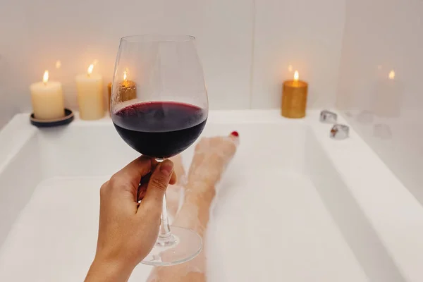 Γυναίκα πίνοντας κόκκινο κρασί, ενώ λαμβάνοντας μπάνιο με αφρό — Φωτογραφία Αρχείου