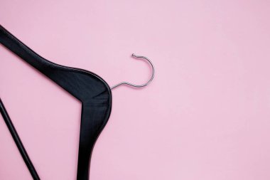 Pembe arka plandaki kıyafetler için boş siyah askı