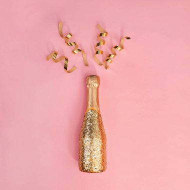 Altın parıltısıyla süslenmiş bir şişe şampanya.