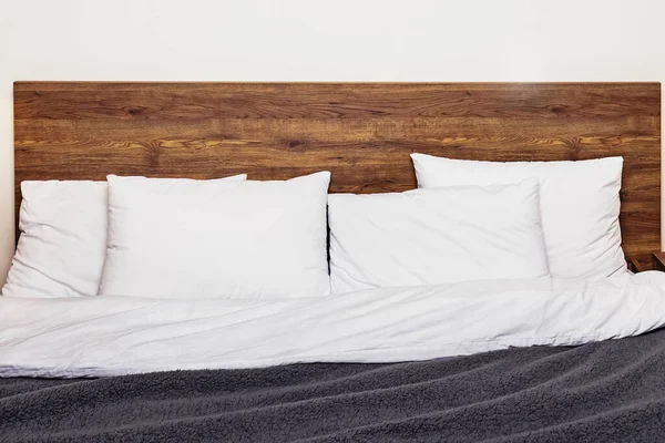 Современный интерьер спальни. Кровать с деревянной спинкой — стоковое фото
