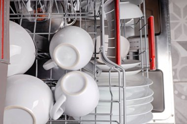 Temiz bardak ve bulaşıklarla dolu bulaşık makinesini aç.