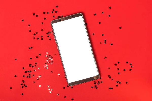 Макет смартфона на красном фоне со звездой конфетти — стоковое фото