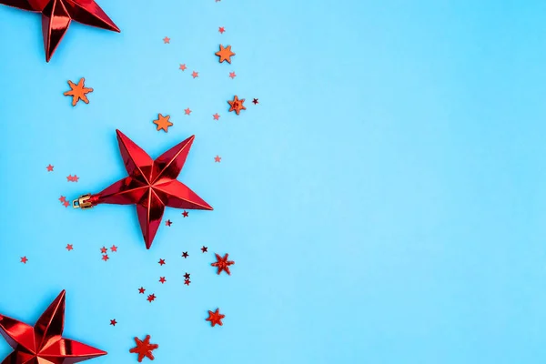 Red Christmas stars and snowflakes on blue background. — Stock Photo, Image