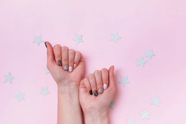 Vrouwen handen met mooie salon manicure in bruine en beige kleuren op de roze achtergrond — Stockfoto