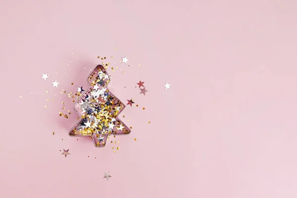 Форма рождественской елки для печенья, наполненного серебром и золотыми звездами — стоковое фото