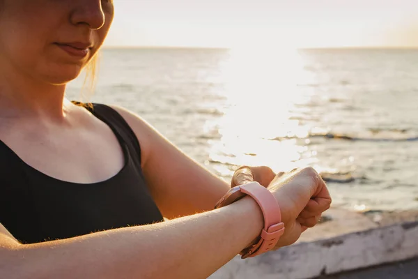 Jonge vrouw controleert haar hartslag bij fitness tracker. — Stockfoto