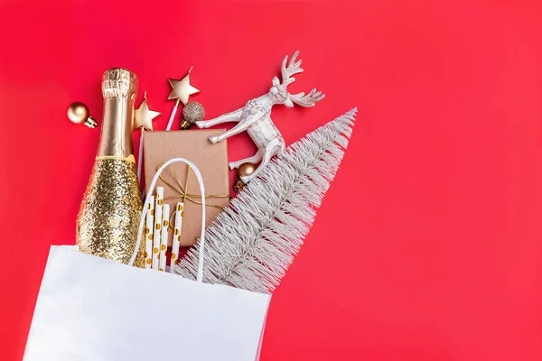 Kerstdecor en geschenken in papieren zak op rode achtergrond. — Stockfoto