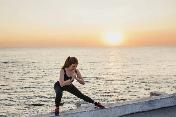 Donna che fa esercizi vicino al mare al mattino — Foto Stock