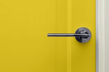 Modern tasarım apartman dairesinde sapı olan parlak sarı bir kapı. 2021 yılının aydınlatıcı ve nihai gri renkleri