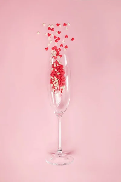 Bicchiere di champagne con piccoli confetti di zucchero a forma di cuore — Foto Stock