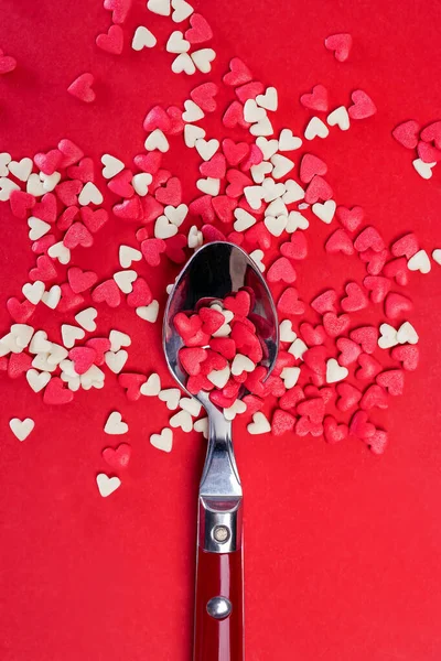 Spoon full of sugar heart shaped sprinkles — Stock Photo, Image