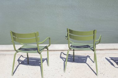 Two empty green metal chairs in Tuileries garden clipart
