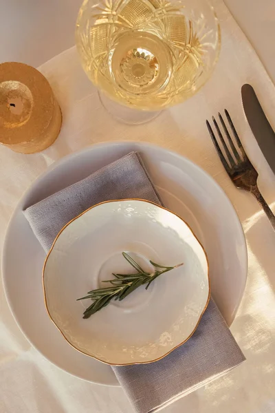 Assiette vintage décorée avec branche de romarin et verre cristallin avec vin blanc — Photo