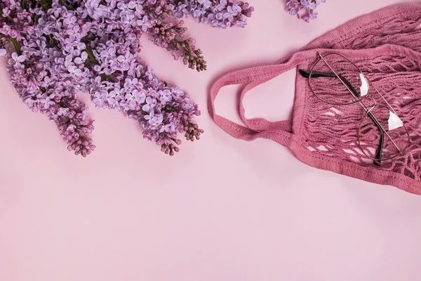 Composición primaveral con flores lila púrpura, bolsa de hilo y gafas. — Foto de Stock