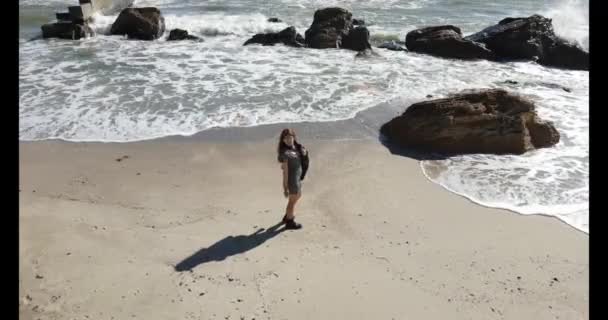 Kvinna i läder stövlar och kort klänning njuter solig dag nära havet — Stockvideo